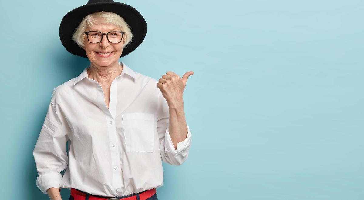 Une dame avec cheveu blanc et chapeau fait du stop sur fond bleu