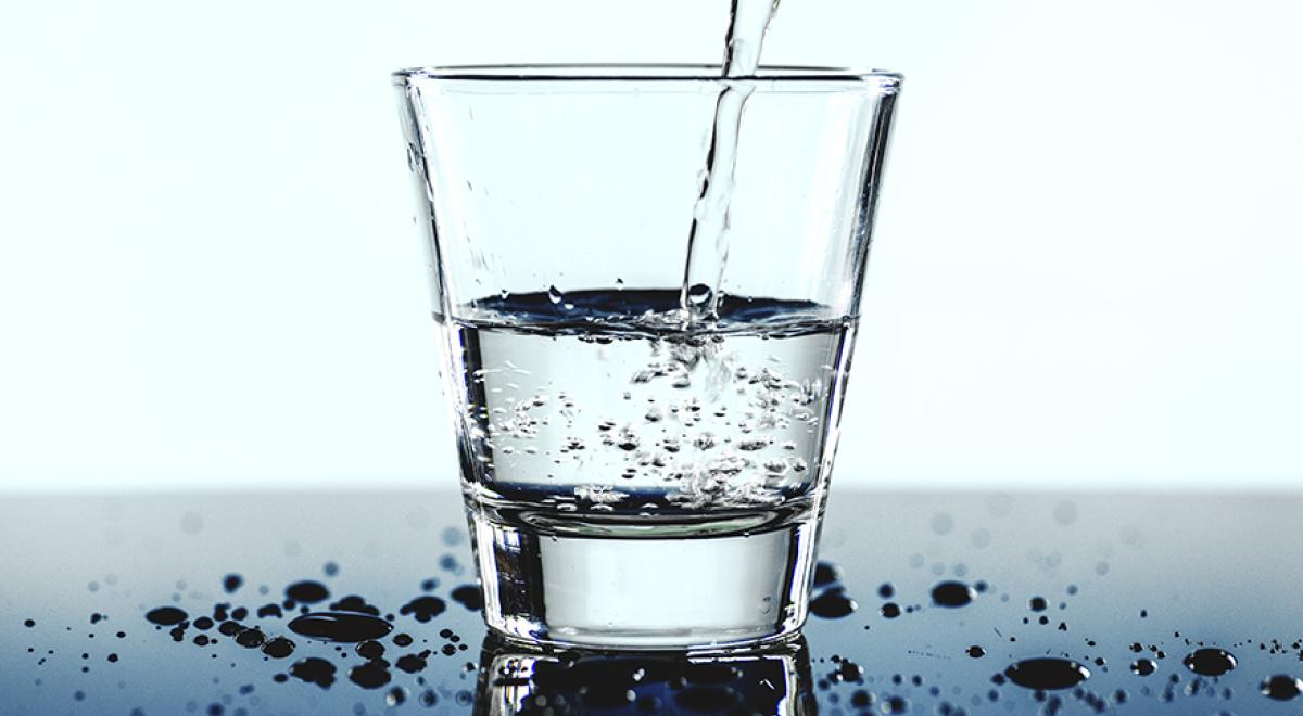 Un verre d'eau transparent sur une table avec quelques gouttes