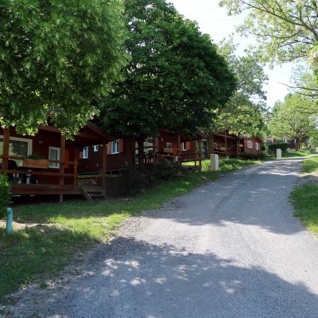 Allée ombragée avec des chalets au camping de Chorges