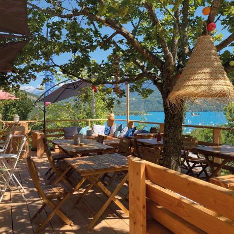 Terrasse ombragée avec parasol en paille et vue sur lac