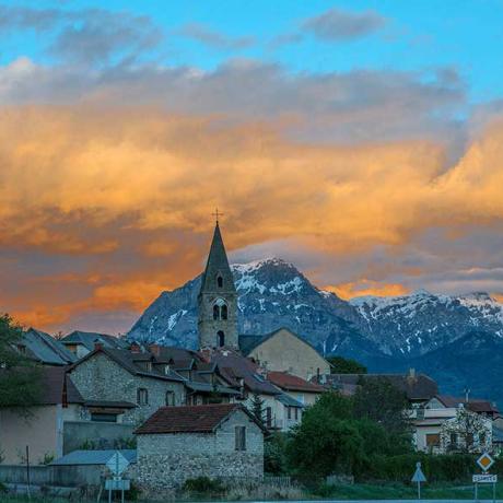 La ville de Chorges au crépuscule sous un ciel flamboyant