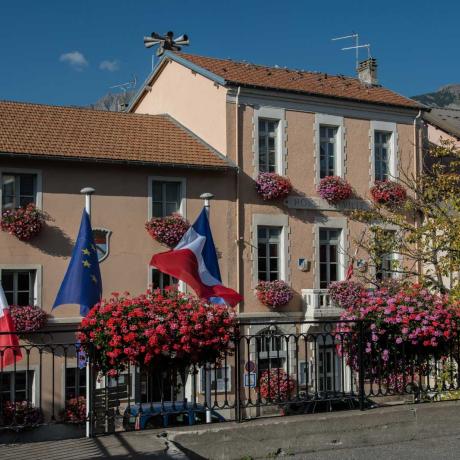 Façade de la Mairie de Chorges dans la Grande rue du bourg avec ses drapeaux