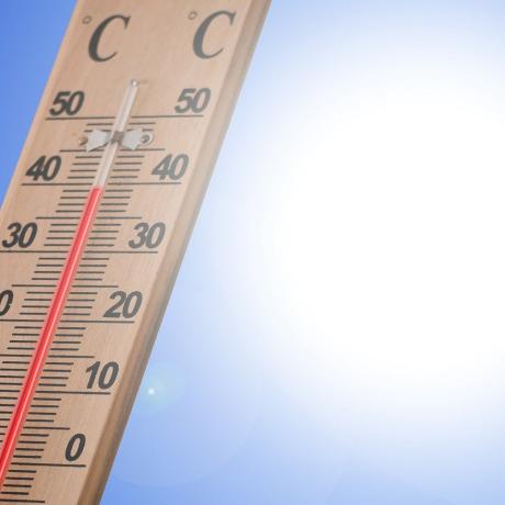 Un thermomètre indique 40° sur fond de ciel bleu avec soleil blanc