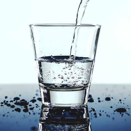 Un verre d'eau transparent sur une table avec quelques gouttes